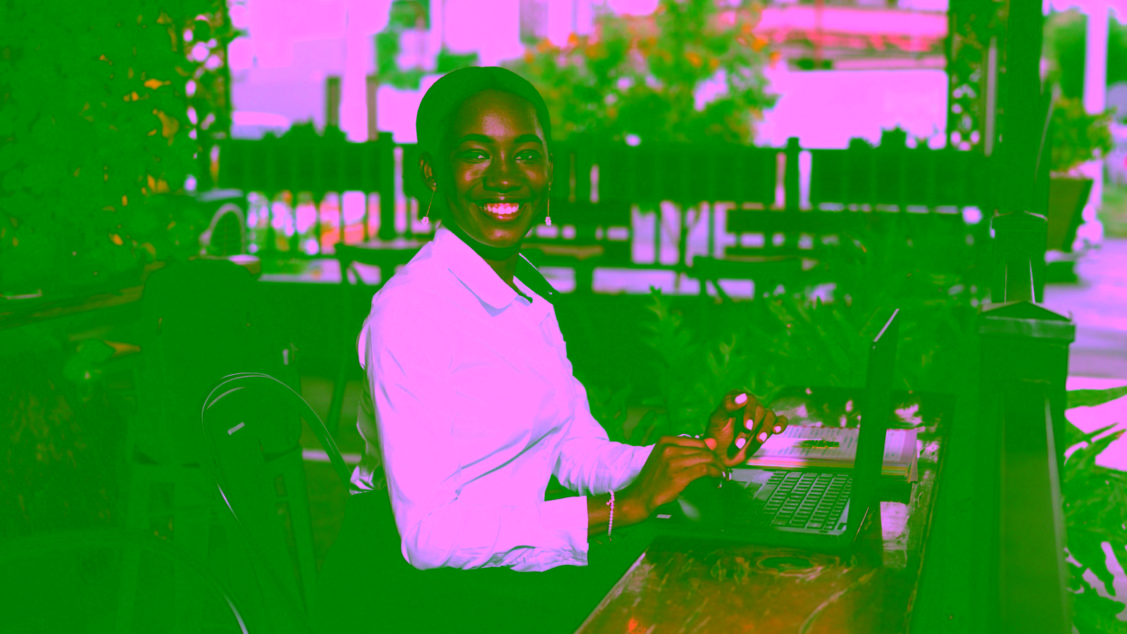 Woman working on laptop at a café terrace