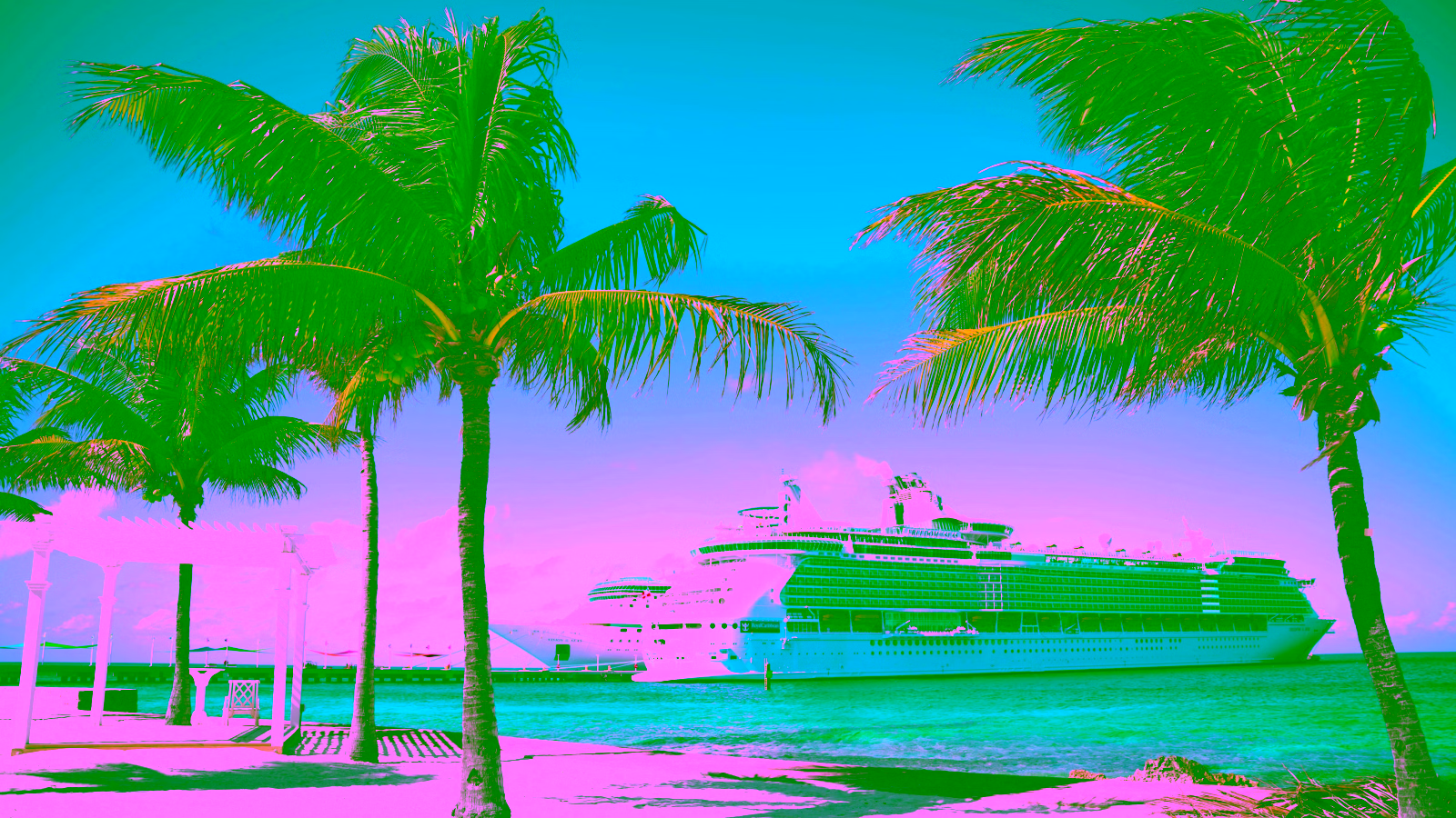 Tropical beach with palm trees and cruise ships docked by clear blue ocean