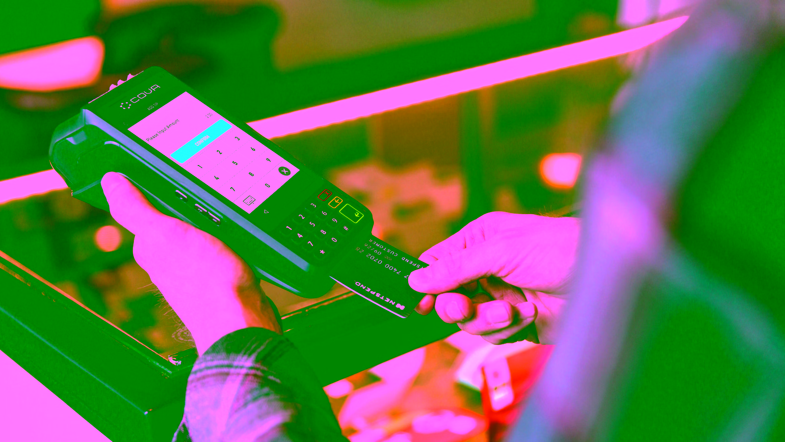 Customer tapping credit card on payment terminal at checkout
