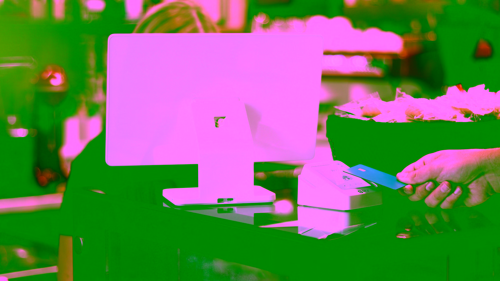 Customer paying with a credit card at a modern point-of-sale terminal in a café