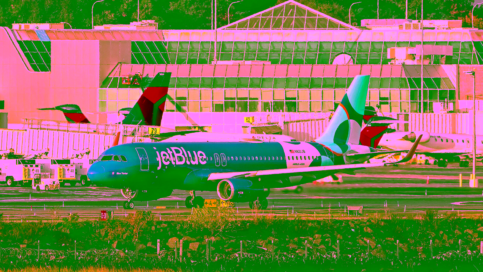 JetBlue airplane taxiing on runway at airport terminal