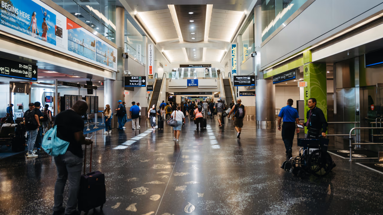 Airport terminal interior with travelers walking and carrying luggage